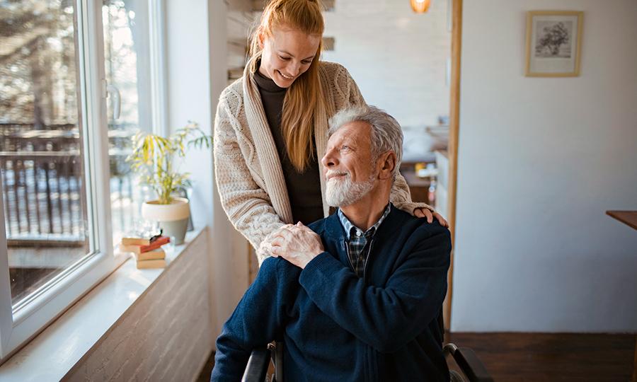 Foto de mujer joven que ayuda a su padre, un adulto mayor