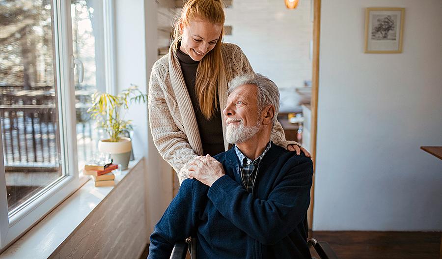 Foto de mujer joven que ayuda a su padre, un adulto mayor