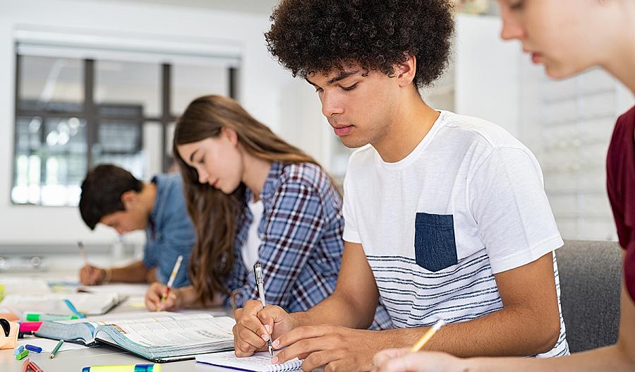 Imagen de estudiantes de secundaria realizando trabajos escolares en clase.
